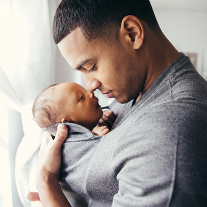 Father holding his newborn close in the LIOR bonding shirt
