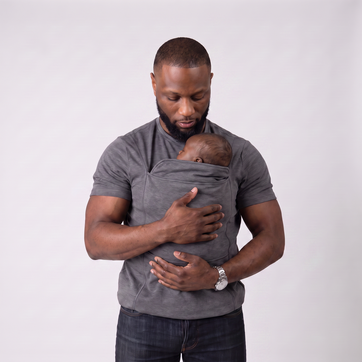 Dad holds his sleeping newborn close, carried in the kangaroo pocket of the LIOR bonding t-shirt